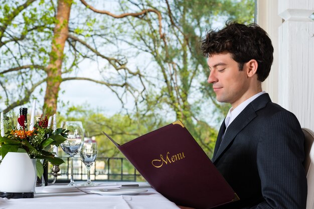 Man of zakenlui met zakenlunch in een gastronomisch restaurant en kies in het menu