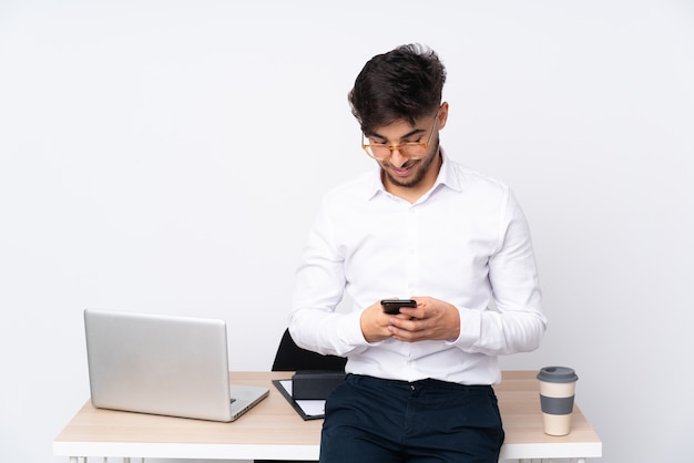 Uomo in un ufficio alla ricerca sul telefono