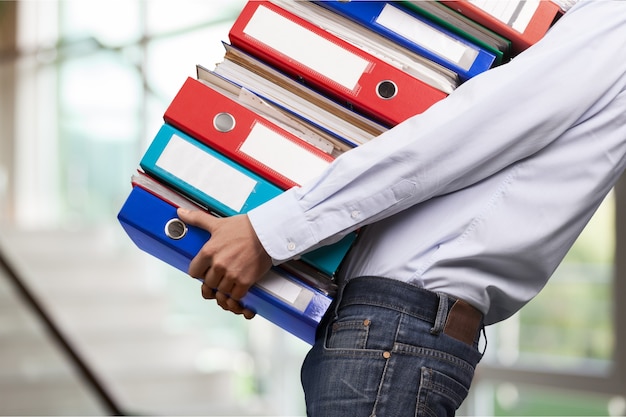 Photo man office worker holding binders stack