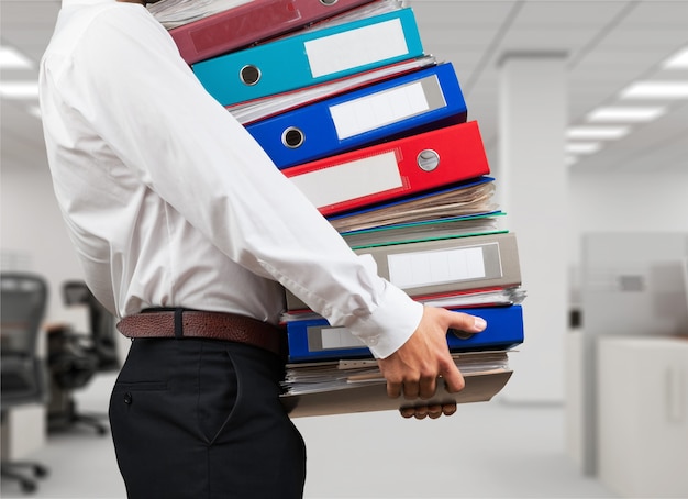 Man office worker holding binders stack