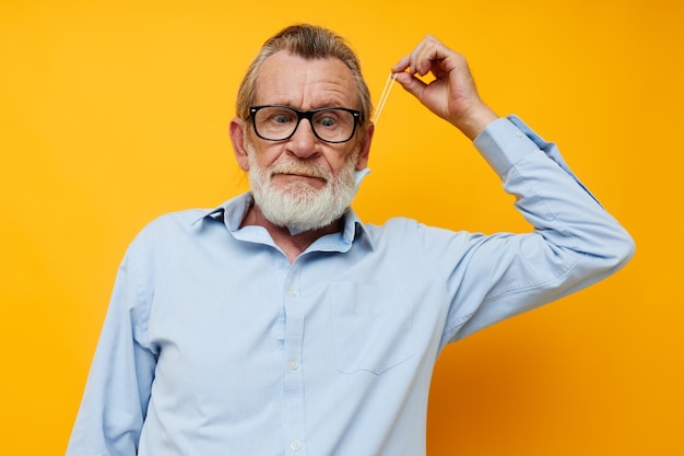 Man old man posing on yellow background