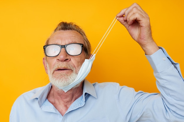 Man old man posing on yellow background