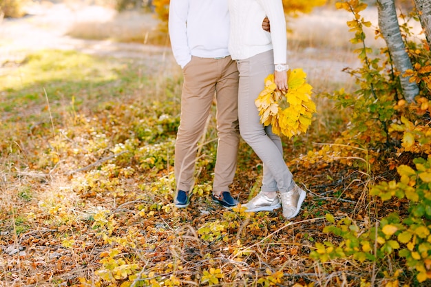 Man omhelst vrouw in de herfst bos vrouw met een krans van gele bladeren in haar handen