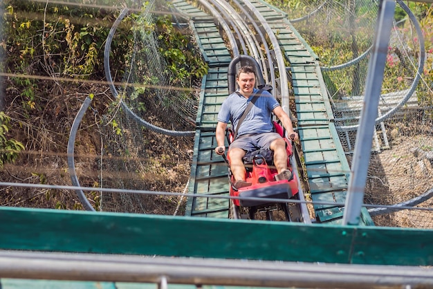 Man on Rail bergafwaarts op een trolley Standpunt tijdens een ritje op Alpine Coaster op rails