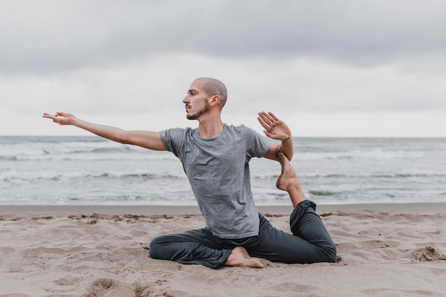 写真 ヨガをしている浜辺の男