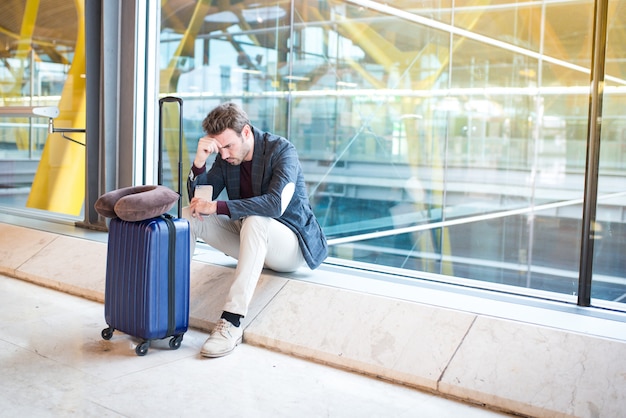 Man ongelukkig en gefrustreerd op de luchthaven zijn vlucht is geannuleerd