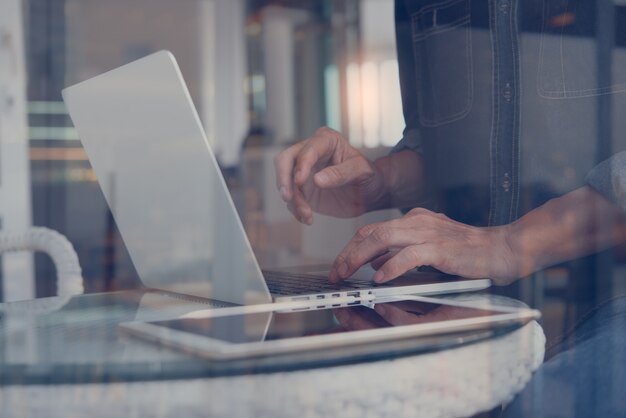 Man online working on laptop computer in coffee shop