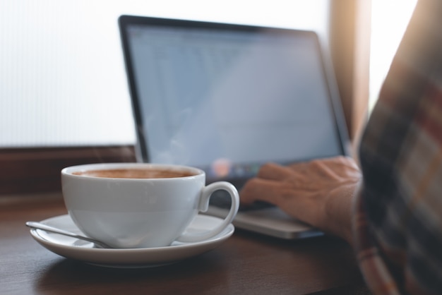 man online working on laptop computer at coffee shop