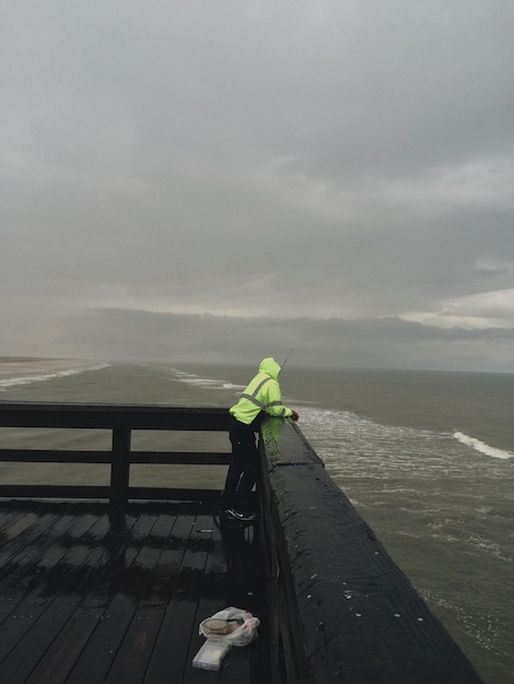 Foto man op de pier bij slecht weer