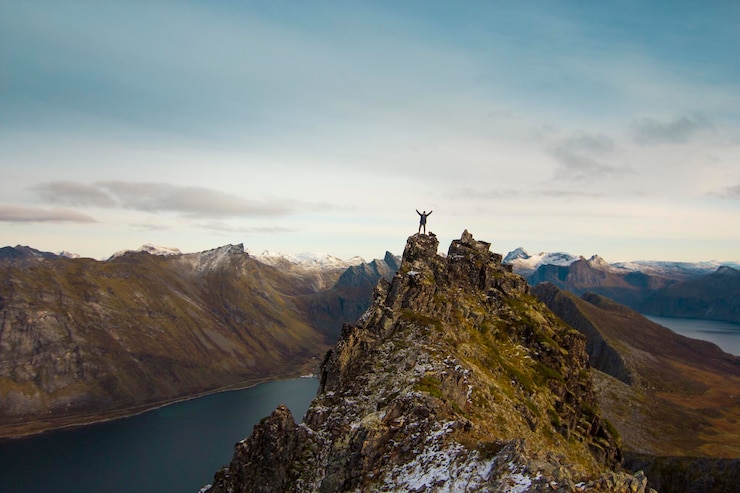 Foto man op de top van een berg in noorwegen