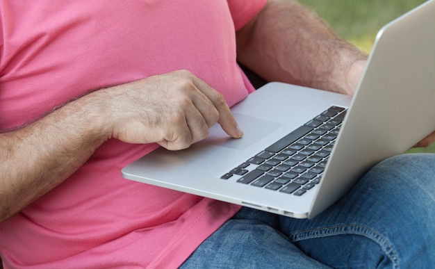 Man op een bankje met behulp van een laptop