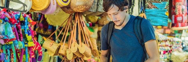 Man op een markt in Bali, een typische souvenirwinkel die souvenirs en handwerk van Bali verkoopt aan de