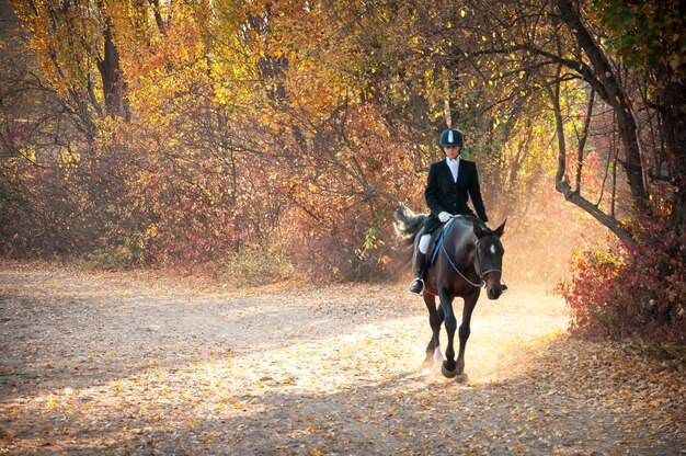 Foto man op een paard in het bos.