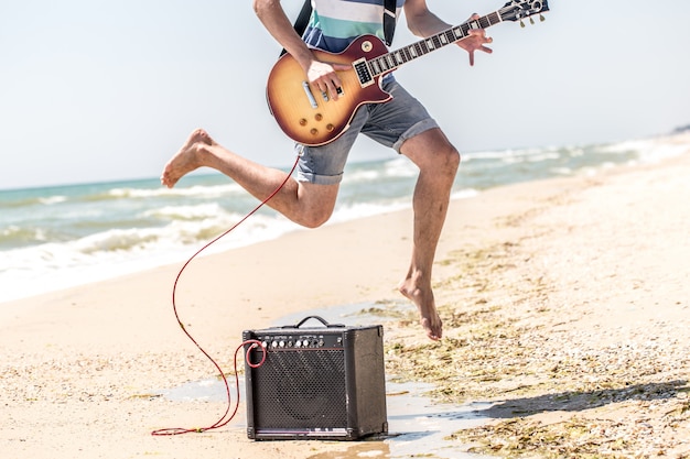 man op het strand met muziekinstrumenten