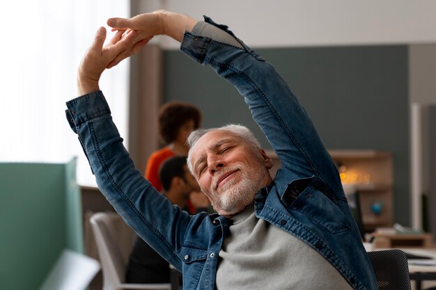 Foto man op kantoor die zich uitstrekt tijdens een werkdag