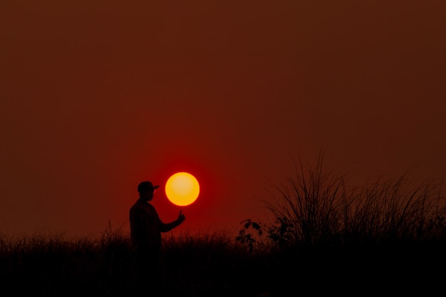 man op rode achtergrond met grote zon