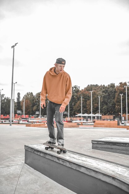 Man op skateboard rijden bolder in skatepark