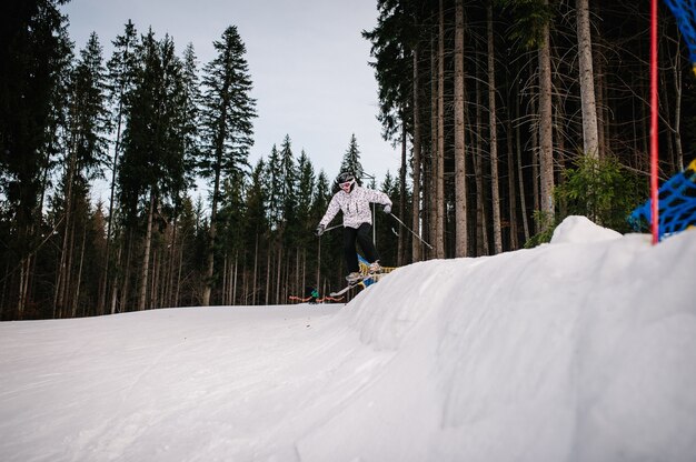 Man op skiën springt van een heuvel vanaf een springplank