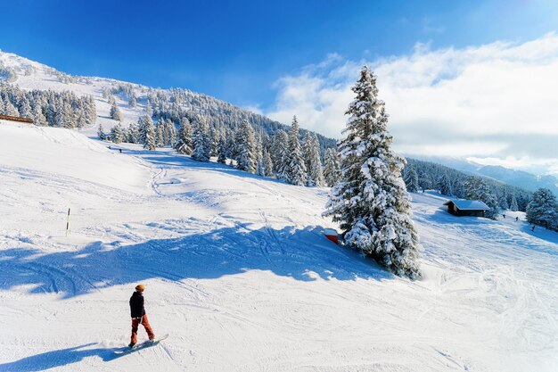 Man op Snowboard in skigebied Zillertal Arena in Tirol in Mayrhofen in Oostenrijk in de winter Alpen. Alpine bergen met witte sneeuw en blauwe lucht. Downhill-plezier op Oostenrijkse besneeuwde pistes.