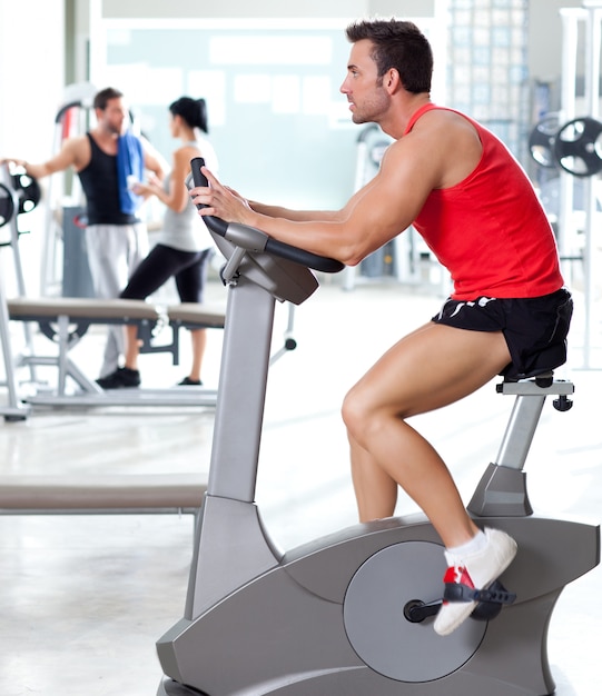 man op stationaire fiets op sport fitness gym