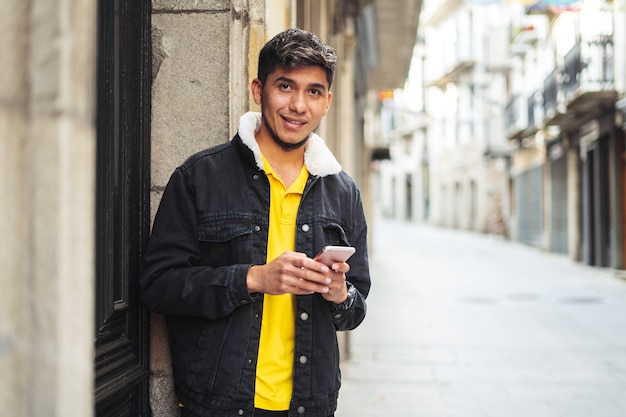 Man op straat van een stad met tablet in de hand kijkend naar camera