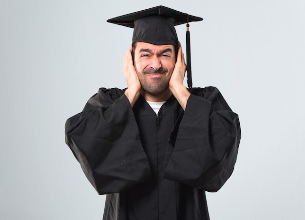 Man op zijn afstuderen dag universiteit beide oren met handen