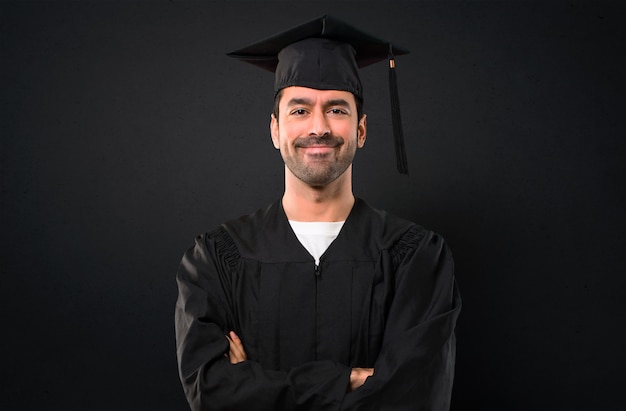 Man op zijn afstuderen dag Universiteit houden de armen gekruist in frontale positie