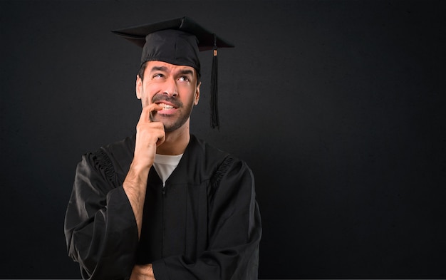 Man op zijn afstuderen dag universiteit terwijl twijfels en met confuse uitdrukking