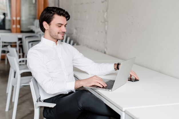 Man op zijn werkplek met laptop op kantoor