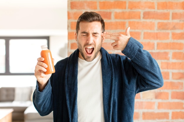 Man op zoek ongelukkig en gestrest, zelfmoordgebaar pistool teken met hand, wijzend naar het hoofd