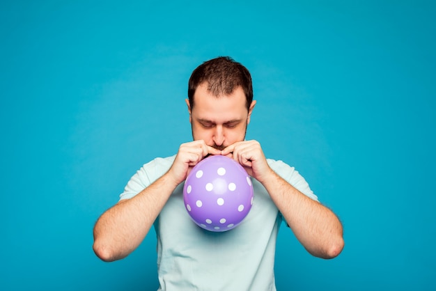 Man opblazen van een paarse ballon