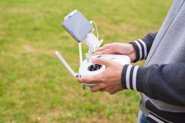 Foto uomo che fa funzionare il drone in volo o in bilico tramite telecomando in natura