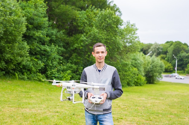 Man Operating Drone Flying or Hovering by Remote Control in Nature