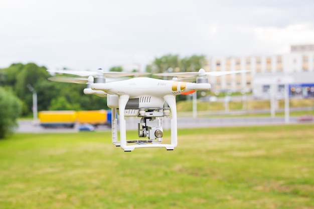 Man Operating Drone Flying or Hovering by Remote Control in Nature