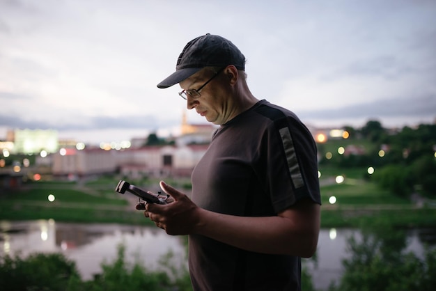 Man operating a drone using a remote controller Man countryside flying drone