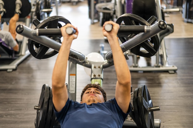 Man opleiding in de sportschool Jonge man doet training