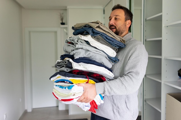 Man opruimen outfit uit grote garderobe kast met stijlvolle kleding en huis spullen hoge kwaliteit foto