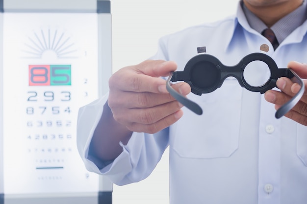 Man at optician holding eyes examined tool to put on patient