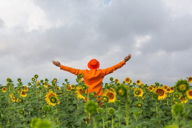 Sunner 해바라기 필드에 주황색 clother에 남자