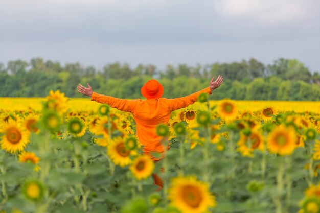 Sunner 해바라기 필드에 주황색 clother에 남자