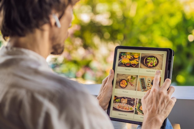 タブレットを使ってオンラインで昼食を注文する男性