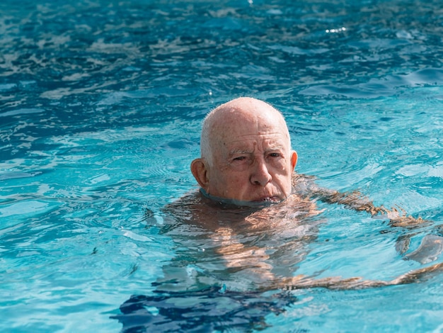 Man ouder dan 80 jaar statisch in het zwembad om zich heen te kijken