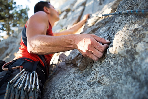 Man outdoors climbing rock wall