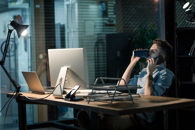 Man overladen met werk met telefoongesprek