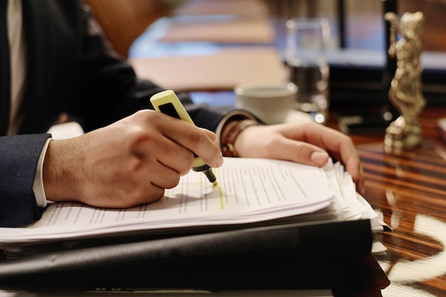 Man Overviewing Document and Highlighting Words in It