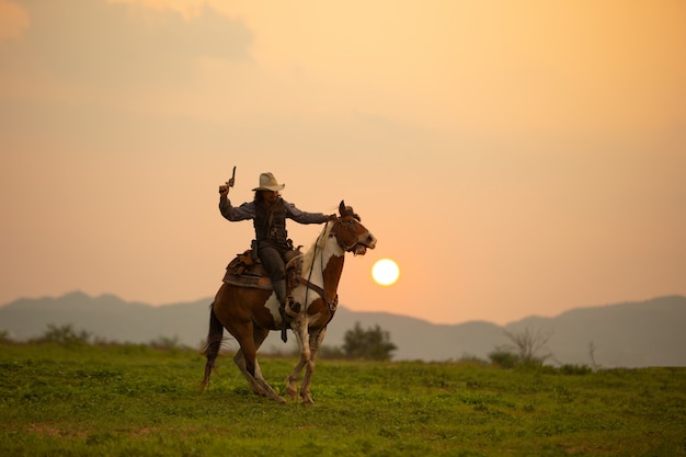 Man paardrijden paard op veld tijdens zonsondergang