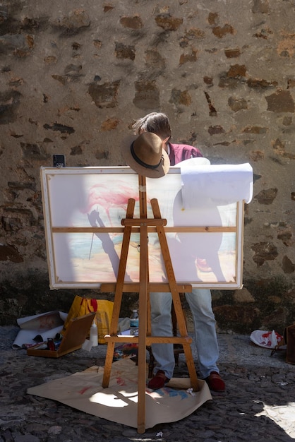 A man painting a picture on a canvas.