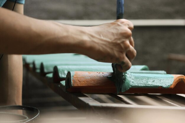 Man painting on roof tile