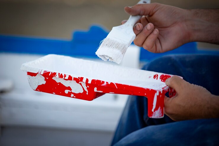 Photo man painting traditional row boat with brush