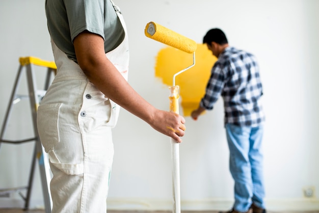 Man painting the walls yellow